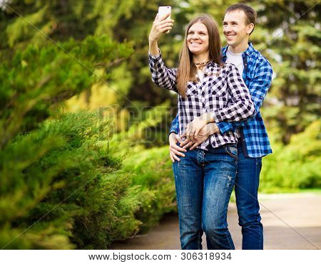 Capturing Bright Moments. Joyful Young Loving Couple Making Selfie On Camera While Standing Outdoors