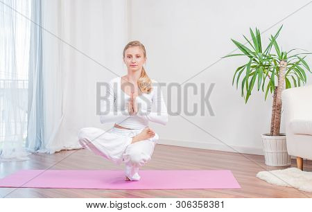 Beautiful Woman Is Practicing Yoga At Home On Yoga Mat, Girl Doing Half Lotus Toe Balance Exercise, 