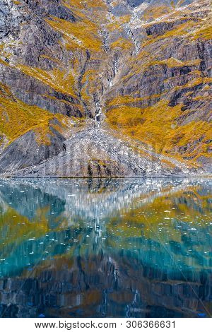 Abstract Nature Scenery With Rocky Mountains Reflecting In Turquoise Water And Small Pieces Of Ice/i