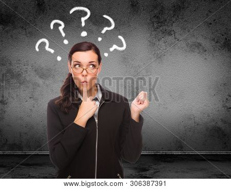 Quesiton Marks Drawn Above Head of Young Adult Woman In Front of Wall with Copy Space.