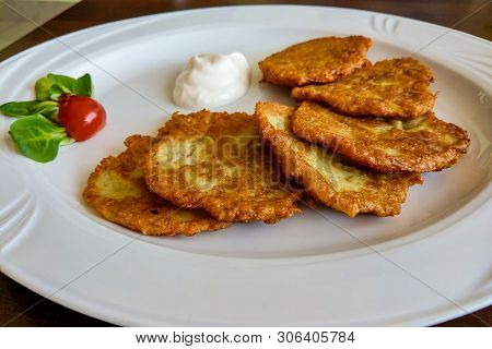 Potato Pancake Dranik With Sour Cream On A White Plate, A Traditional Dish.