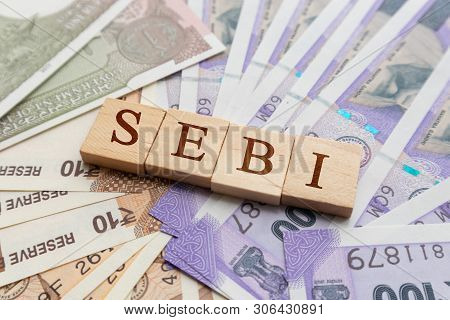 Sebi In Wooden Block Letters On Indian Currency.