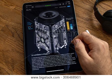 Paris, France - Jun 6, 2019: Man Reading On Apple Ipad Pro Tablet About Powerful Professional Workst