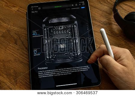 Paris, France - Jun 6, 2019: Man Reading On Apple Ipad Pro Tablet About Powerful Professional Workst