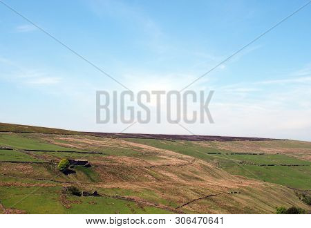 A Scenic View Of Green Meadows And Stone Walls Underneath Hills And Moorland On The Old Howarth Road