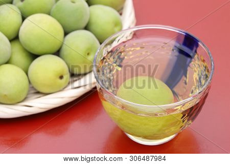 Japanese Plum Wine Called Umeshu, On Red Background