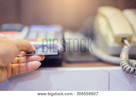 Hand Put Credit Card In Slot Of Credit Card Reader And Telephone.