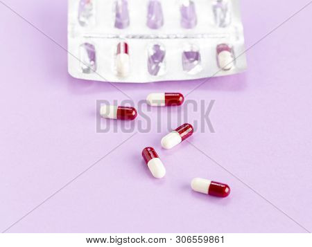 Blister Packaging Of Red And White Capsules On A Colored Background