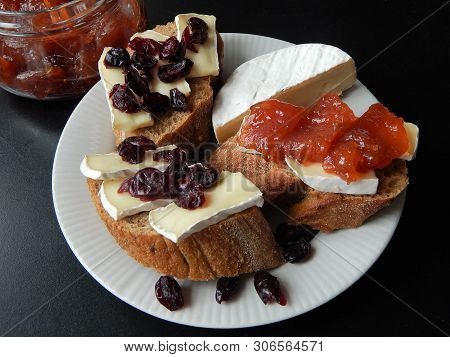 Sliced ​​camembert Cheese On Buckwheat Baguette With Dried Cranberries And Quince Confitures And A H