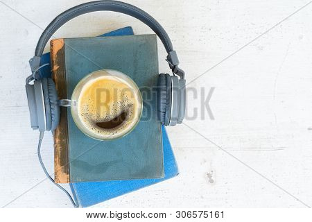 Audio Book Concept. Headphones With Books And Cup Of Coffee On Wooden Table. Top View With Copy Spac