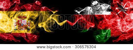 Spain Vs Oman, Omani Smoky Mystic Flags Placed Side By Side. Thick Colored Silky Smokes Flag Of Span
