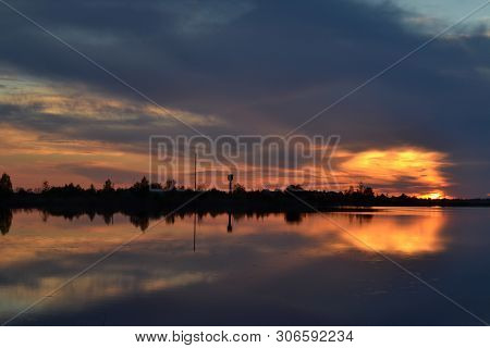 Sunset On Cloudy Sky Over The Lake