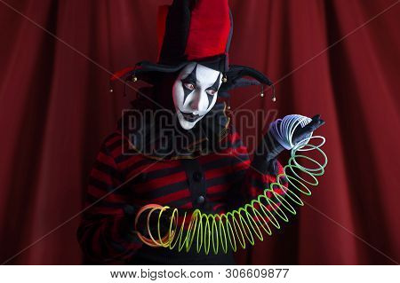 Cute Jester Woman Showing Performance With Rainbow Spring Toy.
