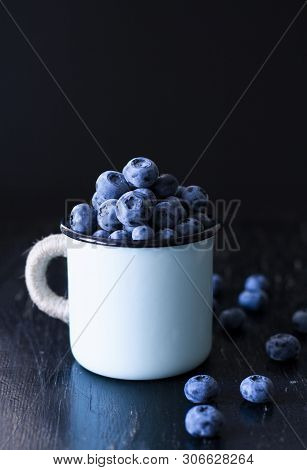 A Tasty And Healthy Snack: A Mug Of Juicy And Sweet Blueberries On The Black Background.