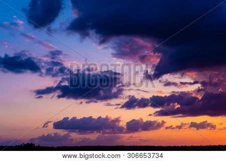 Evening Sky At Sunset Background. Dark Clouds Hanging Above Horizon. Majestic Cloudscape In Blue, Or