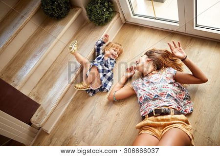 Babysitter with child having fun on the stairs 