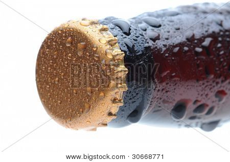 Close de uma tampa de garrafa de cerveja marrom e pescoço coberto com condensação. Formato horizontal sobre um whit