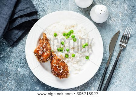 White Rice With Green Peas And Roasted Teriyaki Chicken Thighs. Table Top View