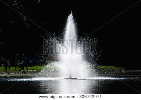 Poland. Wroclaw. May 28. 2019. A Small Fountain In The Lake. Against The Backdrop Of Trees