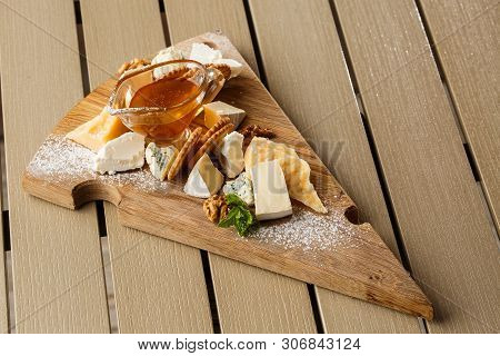 Tasting Cheese Dish On A Wooden Plate. Food For Wine And Romantic, Cheese Delicatessen On A Wooden R