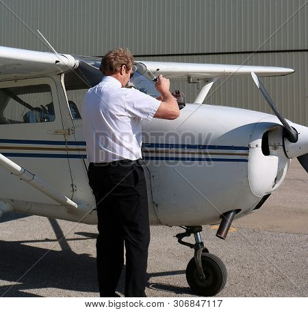 Pilot In Uniform Doing Pre-flight Inspection Before Take Off - Safety First Concept