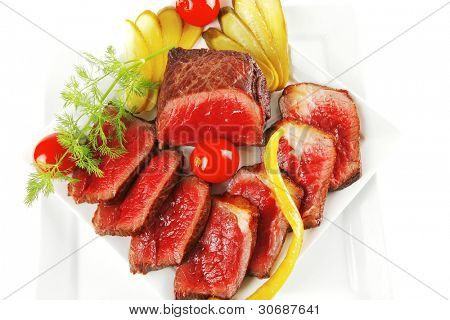 半生的牛肉肉与蔬菜在白板上