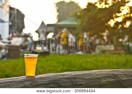 Beer In A Plastic Glass Close-up. Alcoholic Beverage At The Festival. Bakal On A Wooden Board.