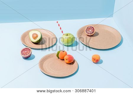 Composition Of Fresh Apricots, Cut Avocado And Blood Orange, Apple With Straw Sticking From It On Di