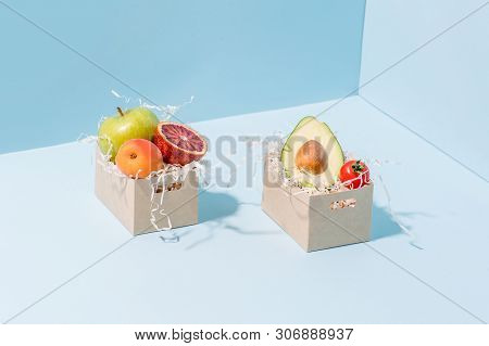 Fresh Vegetables And Fruits Resting In Two Disposable, Compostable Paper Boxes, Filled With Saw Shav