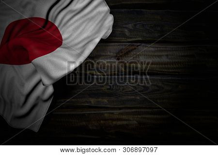 Beautiful Dark Picture Of Japan Flag With Large Folds On Old Wood With Free Place For Your Content -