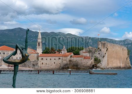 Budva, Montenegro Statue Of A Ballerina Dancer Of Budva Against The Old Town Of Budva Near Mogren Be