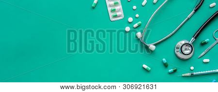 Pills And Medical Equiupments Including Stethoscope, Syringe And Scissors At Border On Green Banner 