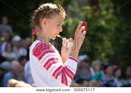 Ivano-frankivsk Reg, Ukraine - Jun. 15, 2019: Girl With A Smartphone At The Festival Polonynsky Summ