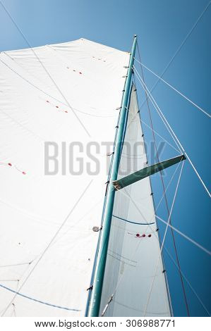 White Cloth Fabric, Masts And Ropes Close-up On The Sail Of Tri-yacht Or Yacht Sailing Boat