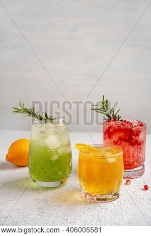 Three Colorful Summer Cocktails In Glasses On White Table. Assortment Of Fresh Summer Drinks. Red Sa