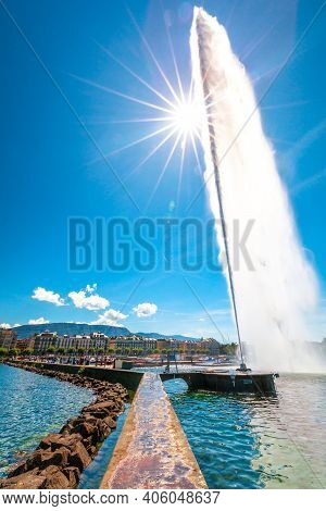 View Of Jet Deau Fountain In Geneva Lake With Sunrays. Jet Fountain Which Projects Its Water Spray 1