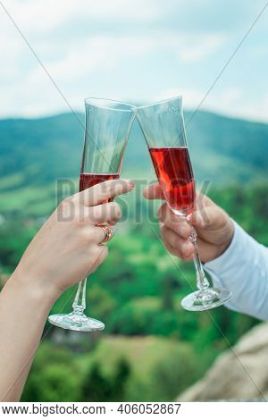 Glasses With Red Champagne Drink In Bride And Groom Hands. Happy Newlyweds Drinking. Loving Couple C
