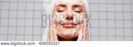 Happy Woman With Closed Eyes Applying Foam Cleanser In Bathroom, Banner