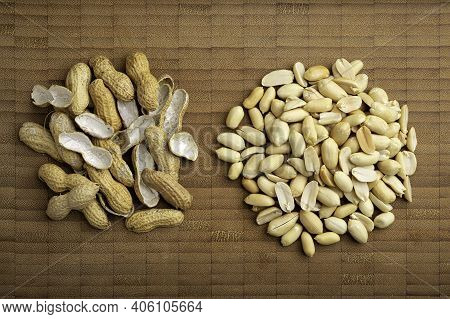 Flat Lay Image Of Peeled Peanuts Seeds And Shells On Bamboo Cutting Table. (arachis Hypogaea) Edible