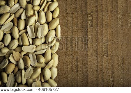 Top View Of Peeled Peanuts Seeds Close Up On  Bamboo Wooden Background For Copy Space. (arachis Hypo
