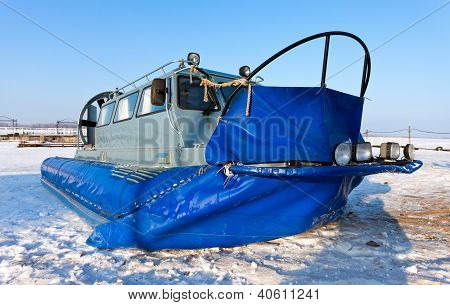 Hovercraft sulla riva di un fiume ghiacciato