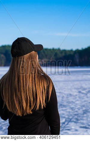 Young Female Woman Back To The Camera With Long Hair In A Snow Landscape. Happy Hipster Girl With Hi