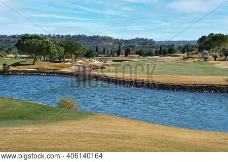 Picturesque Scenery Golf Course Green Field With Trees And Blue Lake During Warm Winter Sunny Day, M