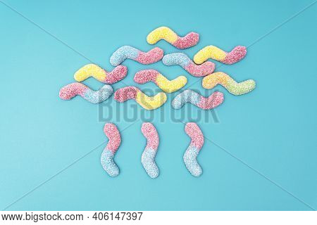 Creative Raining Cloud Flat Lay Made Of Colored Sugar Coated Gummy Worms On A Light Blue Background