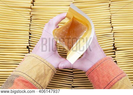 Female Hands Holding A Padded Envelope Open Over A Box Full Of Yellow Mailers