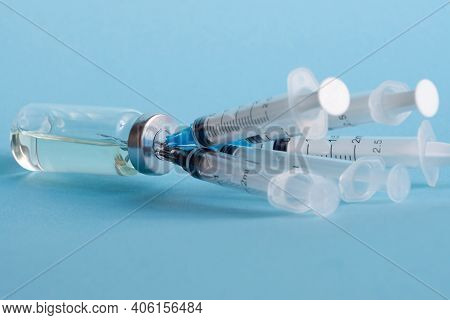 An Ampoule Of Medicine And Five Disposable Medical Syringes Stuck In The Bottle Cap, Close-up On A B