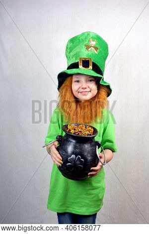 Saint Patricks Day Holiday. Pretty Smiling Small Girl In Green Clothes With Decorative Red Beard And
