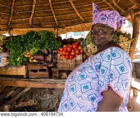 BAMAKO, MALI - CIRCA FEBRUARY 2012: Malian woman selling vegetables on the side of the road.