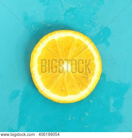 Close Up Of Round Lemon Slice On Blue Background, Fresh Summer Mood. Stock Photo Blank For Your Desi