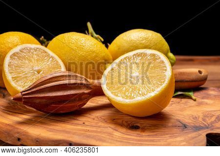 Fresh Ripe Yellow Italian Lemons And Wooden Juice Squeezer, New Harvest